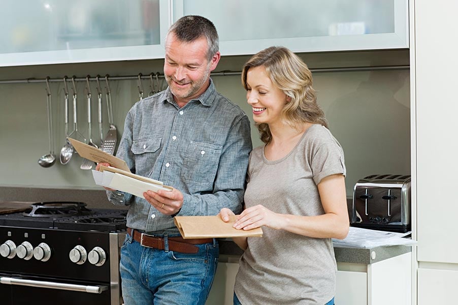 couple holding mail envelopes