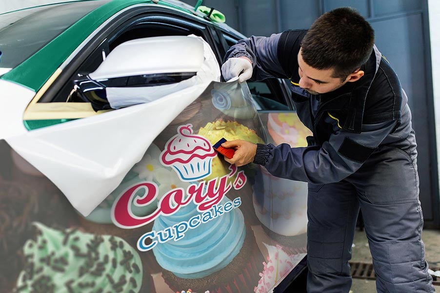 An image of a man applying a vinyl car graphic.