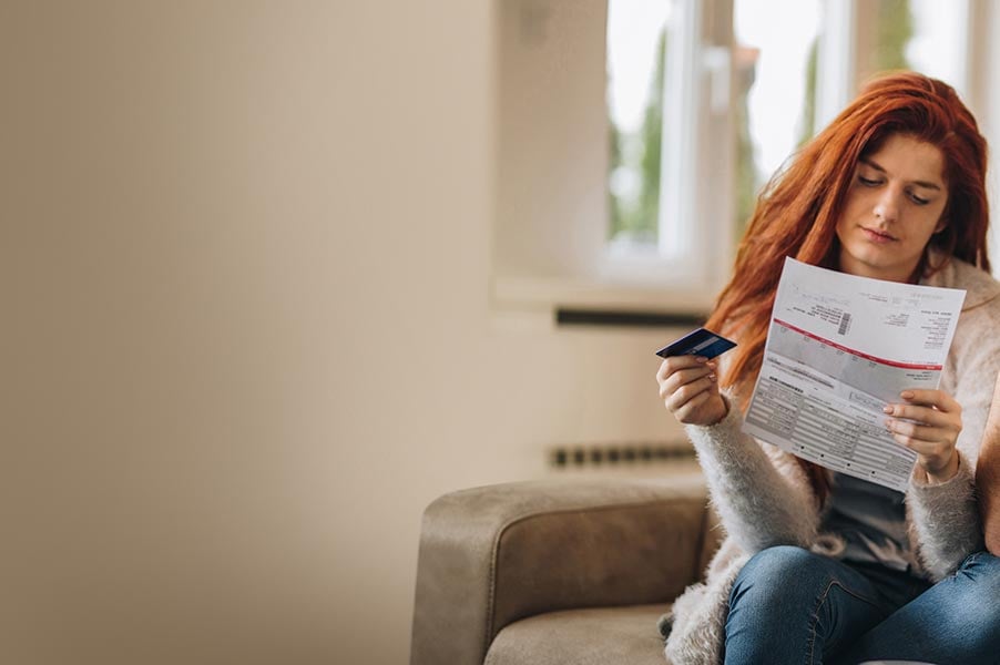 woman holding a credit card reading a form