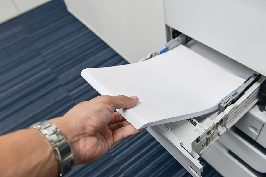 Office paper being loaded into a printer