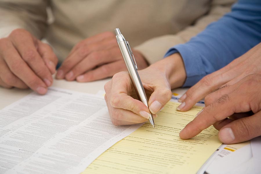 An image of people filling out documents.