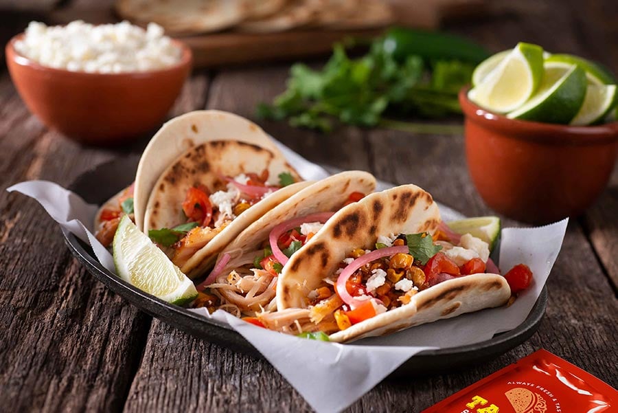 An image of tacos in a paper lined tray.