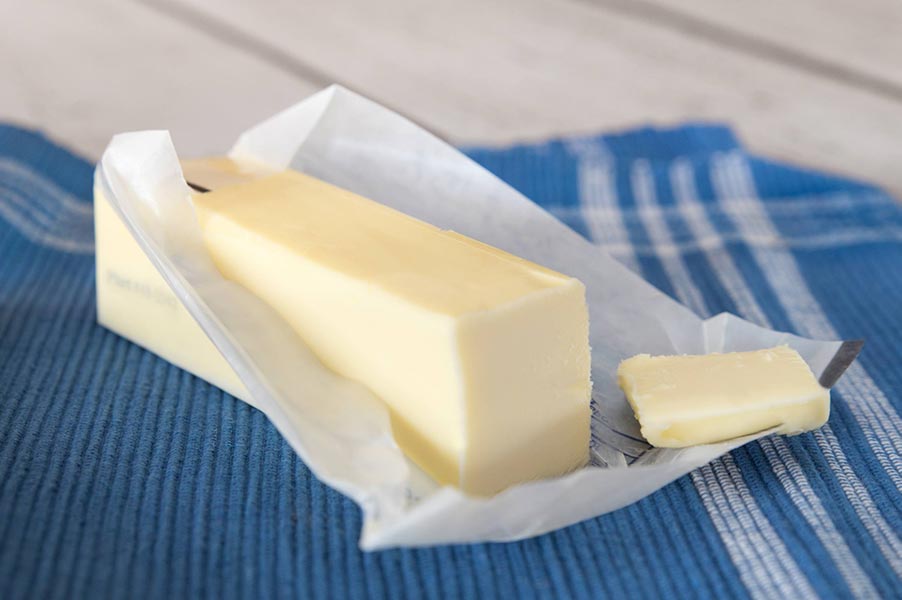 Stick of butter with paper wrap.
