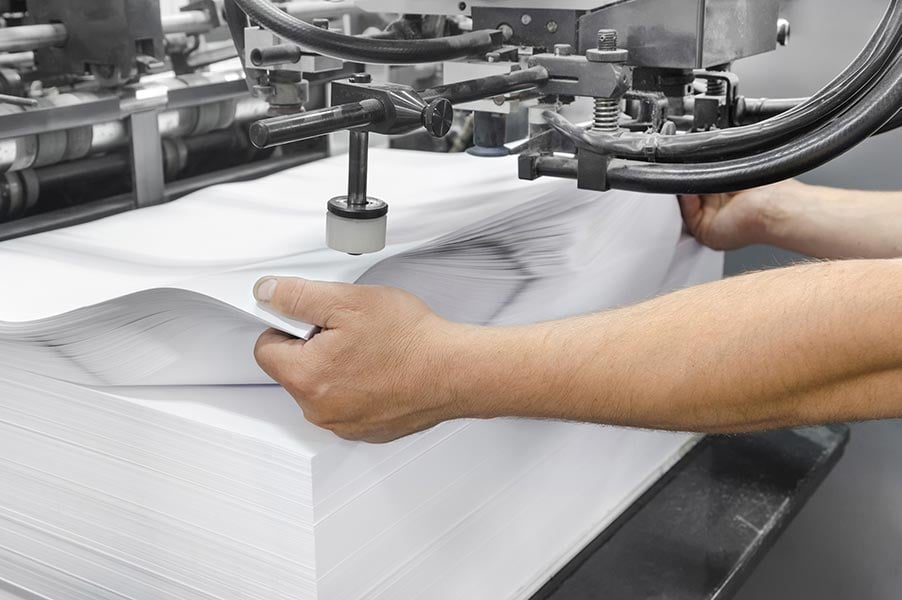Large stack of paper being pressed